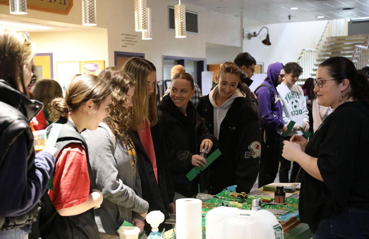 Students smile and laugh as they stop by one of the tables during the 2024 Climate Teachi-In